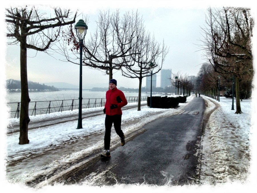 Joggers and cyclists (each avoidng the snow) share the bare pavement